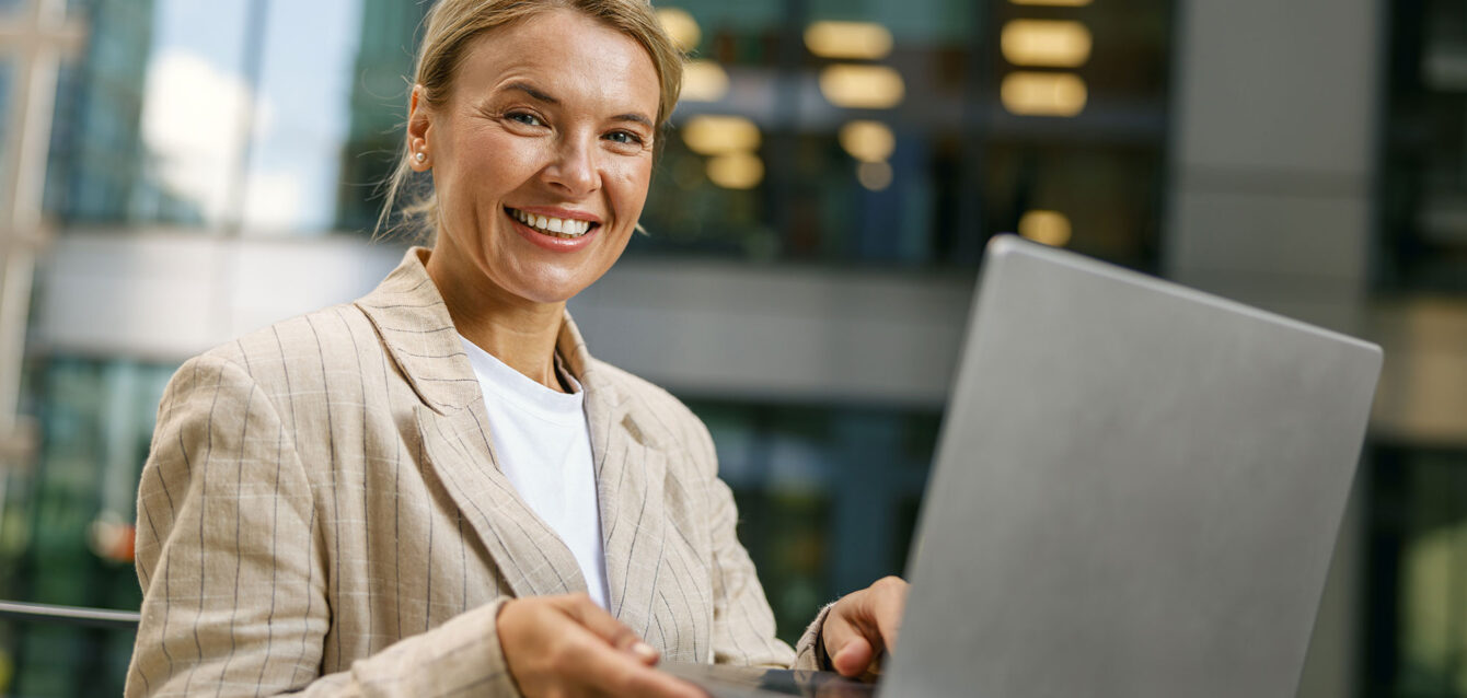 smiling-female-freelancer-working-laptop-on-modern-2024-10-18-08-10-48-utc
