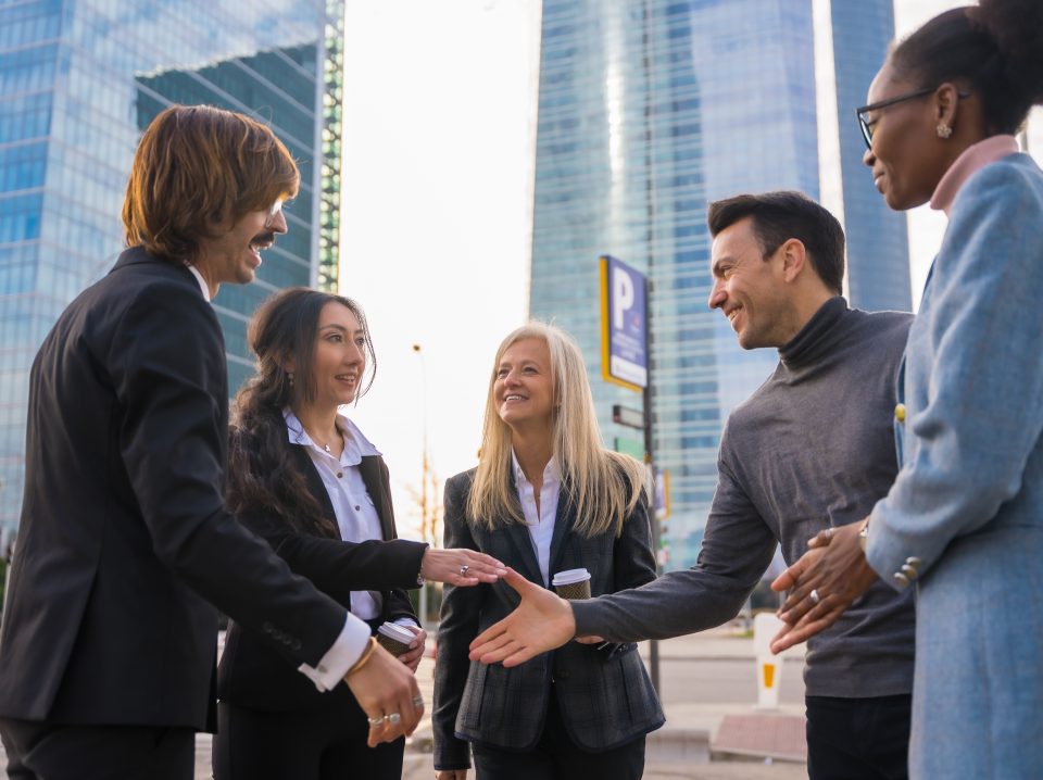 Group of multi-ethnic business people in a business park introducing themselves and shaking hands outdoors